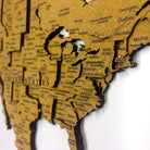 Layered laser-cut cork world map with dark brown edges and labeled continents