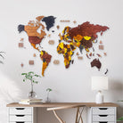 Wooden world map on a wall above a desk with decor items.